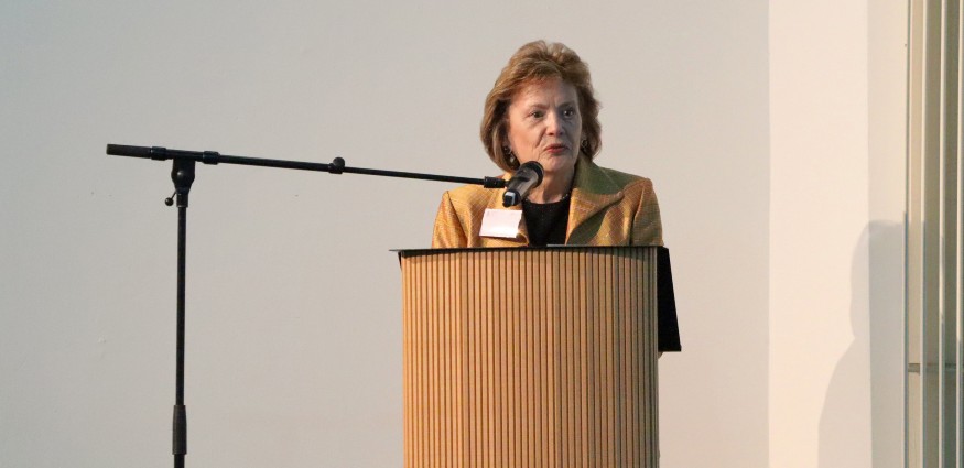 Dr Carolyn Bishop talks into a microphone from a podium.